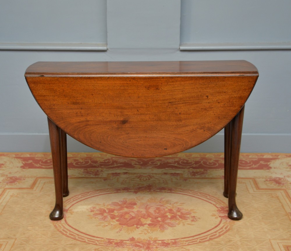 A George II mahogany drop-leaf dining table supported by slender tapered legs ending in pad feet. View XII