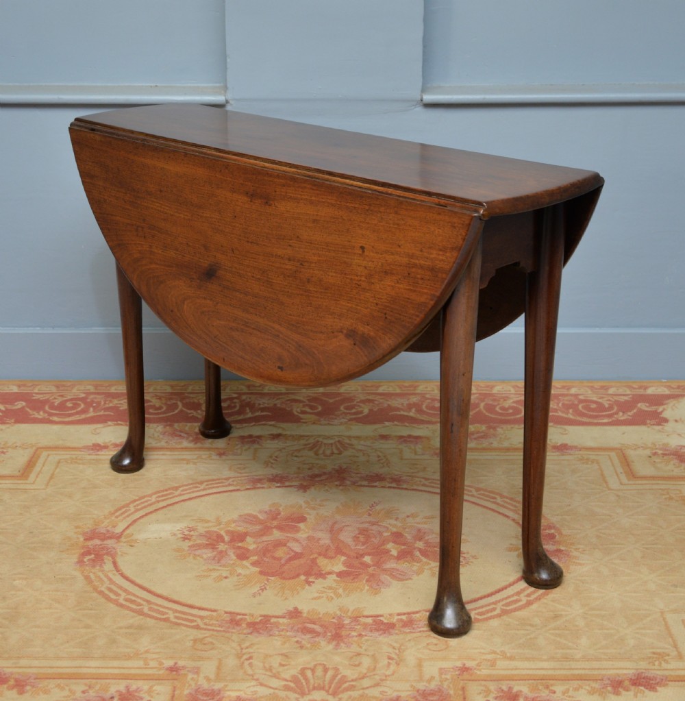 A George II mahogany drop-leaf dining table supported by slender tapered legs ending in pad feet. View XIII