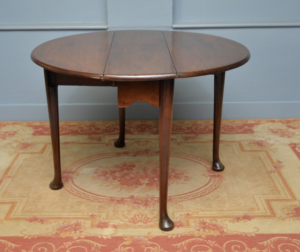 A George II mahogany drop-leaf dining table supported by slender tapered legs ending in pad feet. View XIV