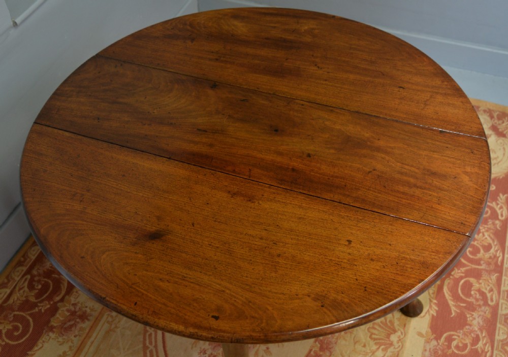 A George II mahogany drop-leaf dining table supported by slender tapered legs ending in pad feet. View XVI