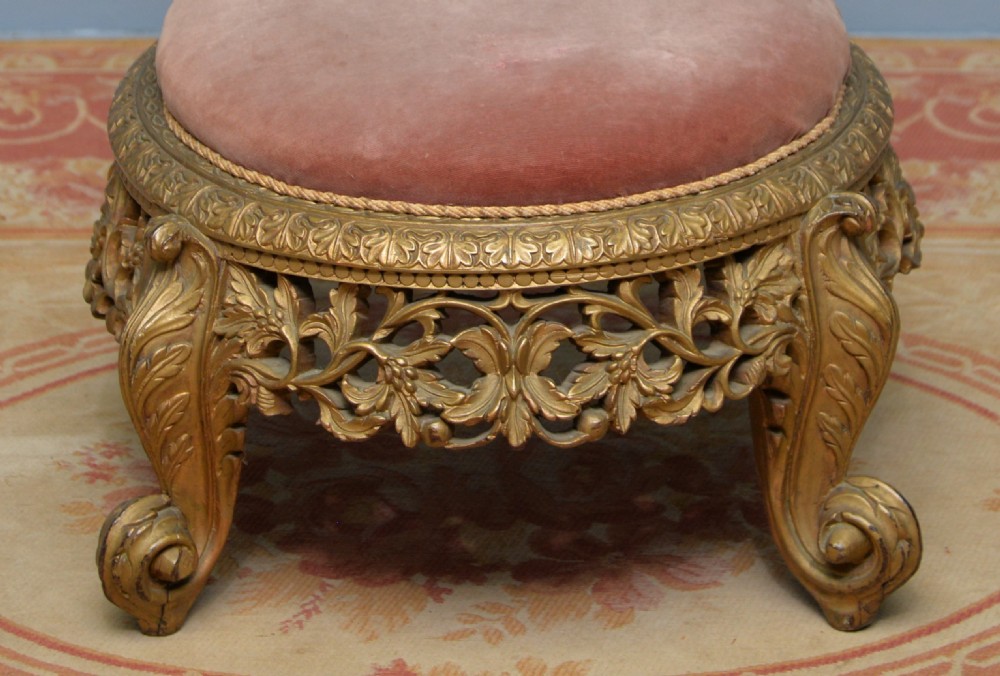 A low 19th-century Anglo-Indian side chair featuring openwork giltwood foliate carving and a round dusty pink velvet seat. View VI