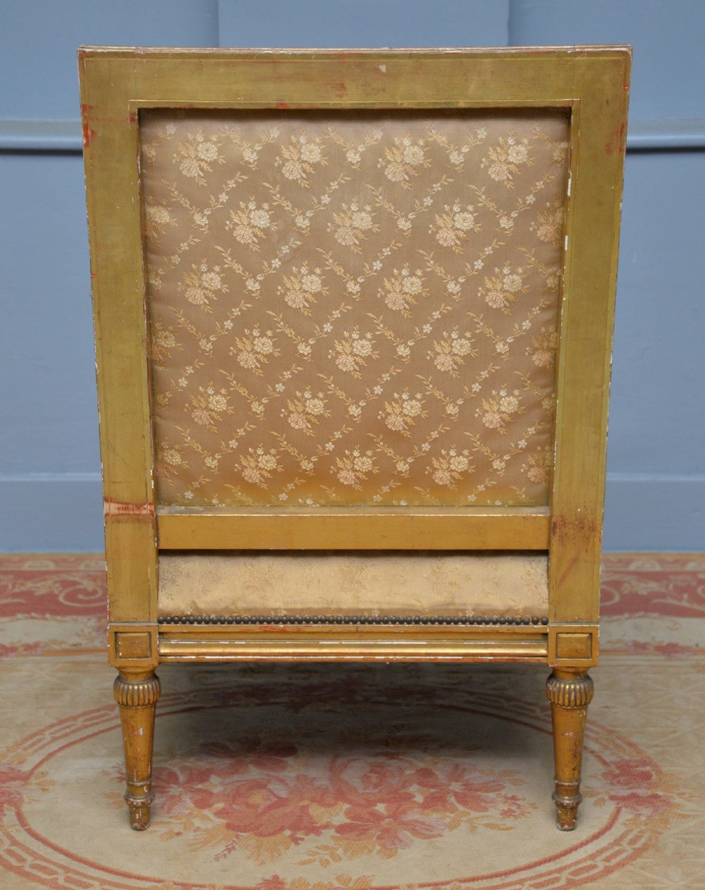 A 19th-century French Louis XVI style bergere armchair with a gilded carved wooden frame, fluted legs, and cream silk damask upholstery. View XI