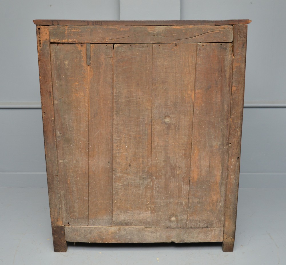 A dark oak 17th-century food court cupboard featuring an upper spindled section with drop finials above a lower two-door panelled cabinet. View XIX