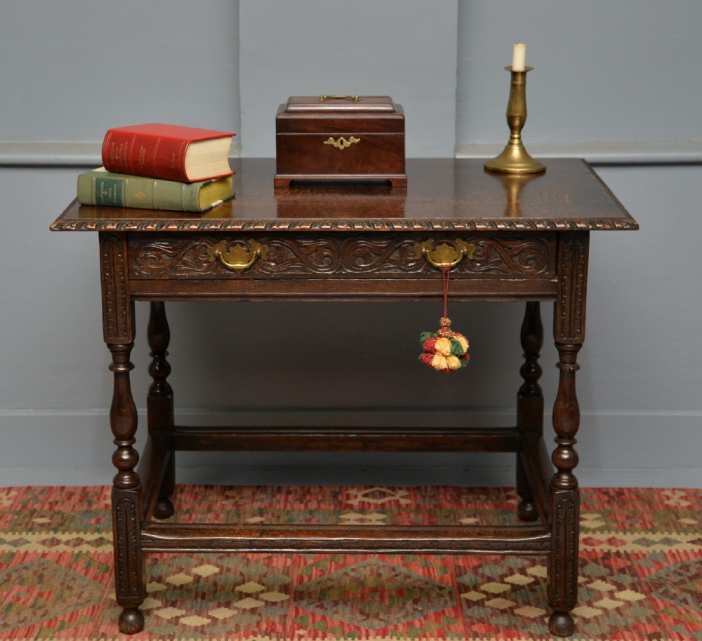 A dark carved oak side table featuring a single scroll-carved frieze drawer, turned legs, and a lower stretcher frame. View II