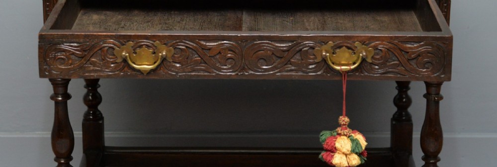 A dark carved oak side table featuring a single scroll-carved frieze drawer, turned legs, and a lower stretcher frame. View IV