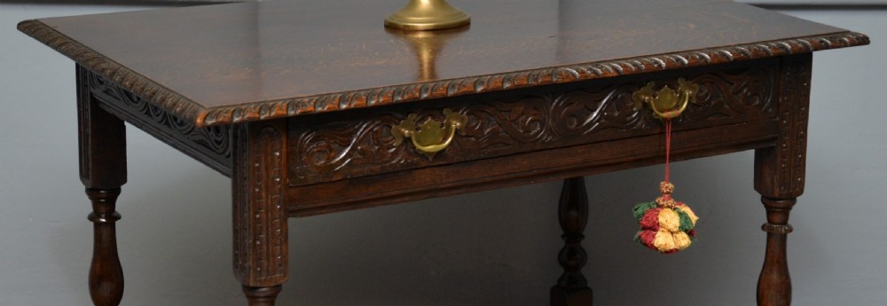A dark carved oak side table featuring a single scroll-carved frieze drawer, turned legs, and a lower stretcher frame. View VIII
