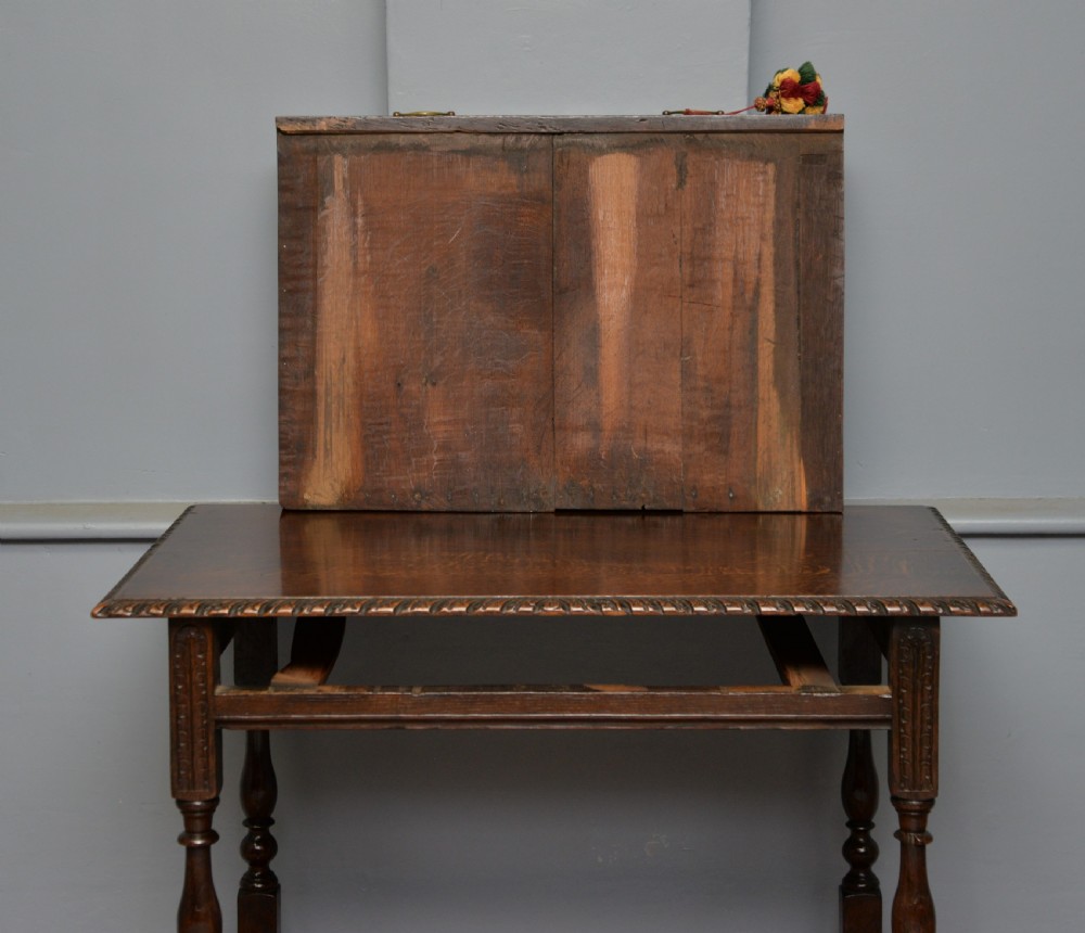 A dark carved oak side table featuring a single scroll-carved frieze drawer, turned legs, and a lower stretcher frame. View XIX