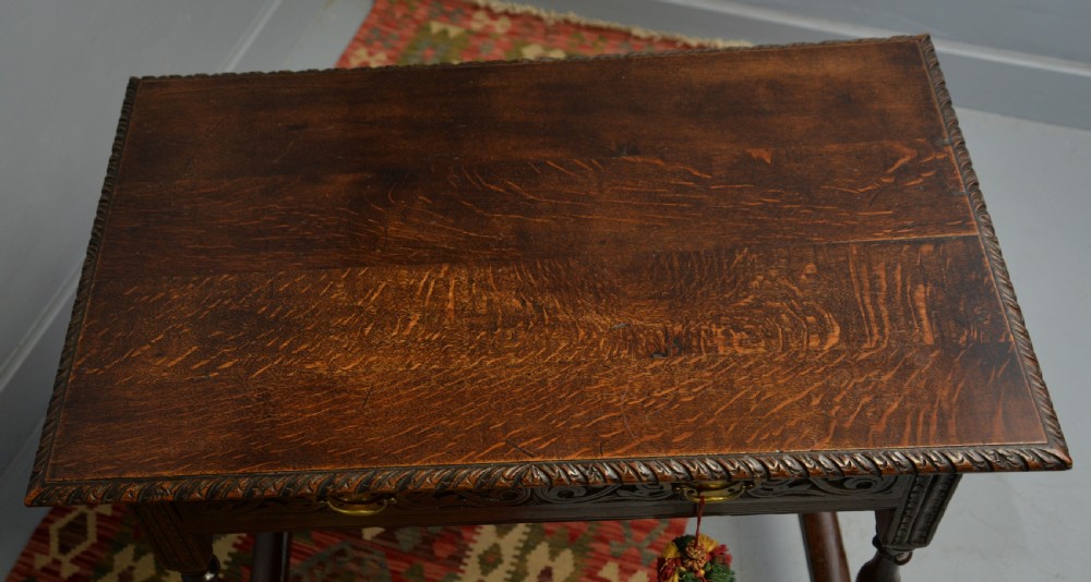 A dark carved oak side table featuring a single scroll-carved frieze drawer, turned legs, and a lower stretcher frame. View XXIII