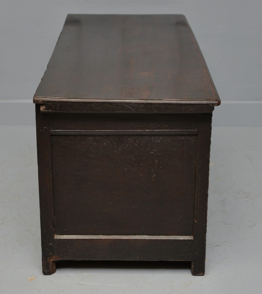 A 17th-century dark oak coffer featuring three carved arcaded front panels with diamond marquetry inlays and detailed frieze carving. View X