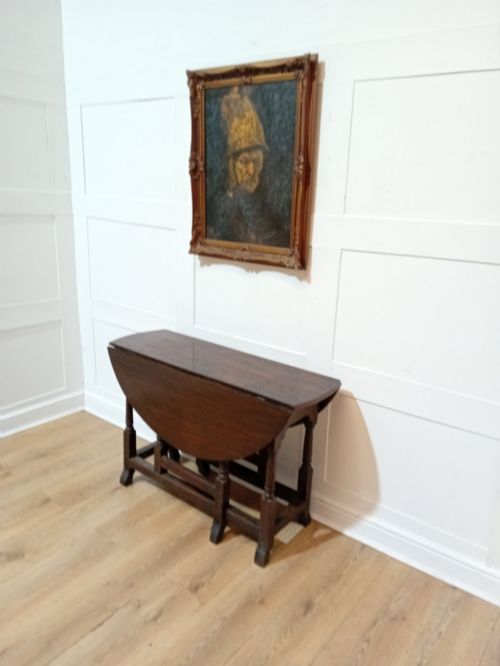 fig 1. A seventeenth-century dark oak gateleg table with folded leaves, turned legs, and a stretcher base.