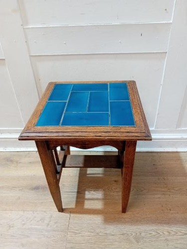 An Arts and Crafts style oak side table featuring a square top inset with vibrant blue ceramic tiles, straight tapered legs, and a lower stretcher shelf. View III