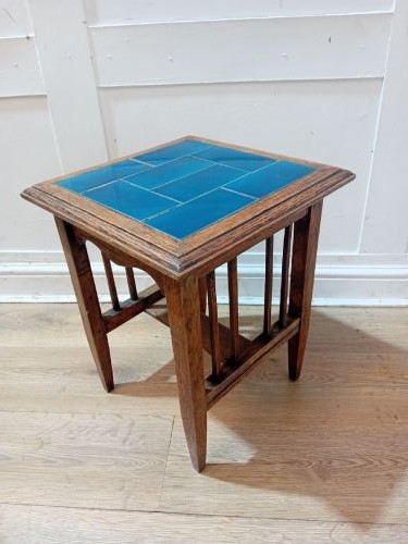 An Arts and Crafts style oak side table featuring a square top inset with vibrant blue ceramic tiles, straight tapered legs, and a lower stretcher shelf. View V