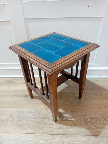 An Arts and Crafts style oak side table featuring a square top inset with vibrant blue ceramic tiles, straight tapered legs, and a lower stretcher shelf. View VII