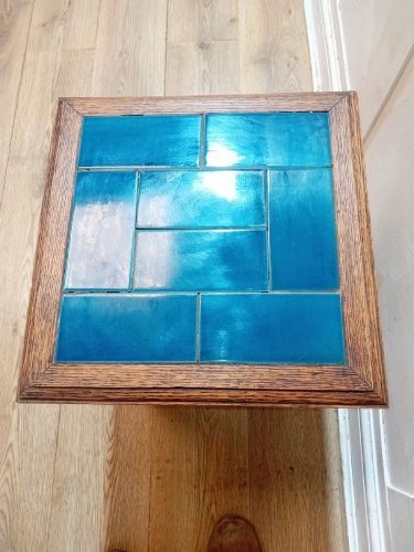 An Arts and Crafts style oak side table featuring a square top inset with vibrant blue ceramic tiles, straight tapered legs, and a lower stretcher shelf. View XIII