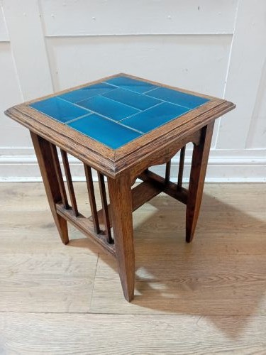 An Arts and Crafts style oak side table featuring a square top inset with vibrant blue ceramic tiles, straight tapered legs, and a lower stretcher shelf. View XI