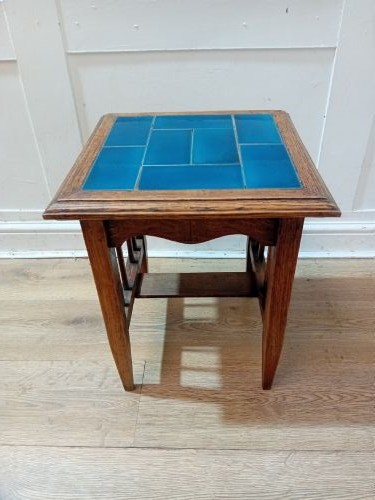 An Arts and Crafts style oak side table featuring a square top inset with vibrant blue ceramic tiles, straight tapered legs, and a lower stretcher shelf. View VIII