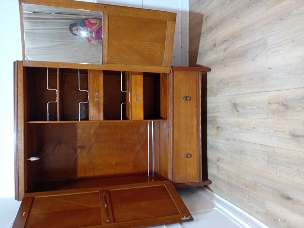 An Edwardian oak compactum wardrobe featuring two panelled doors with chevron oak veneers above a wide single drawer with brass drop handles. View III