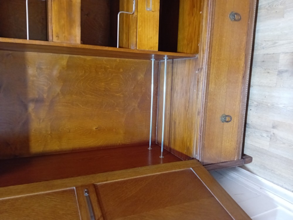 An Edwardian oak compactum wardrobe featuring two panelled doors with chevron oak veneers above a wide single drawer with brass drop handles. View V