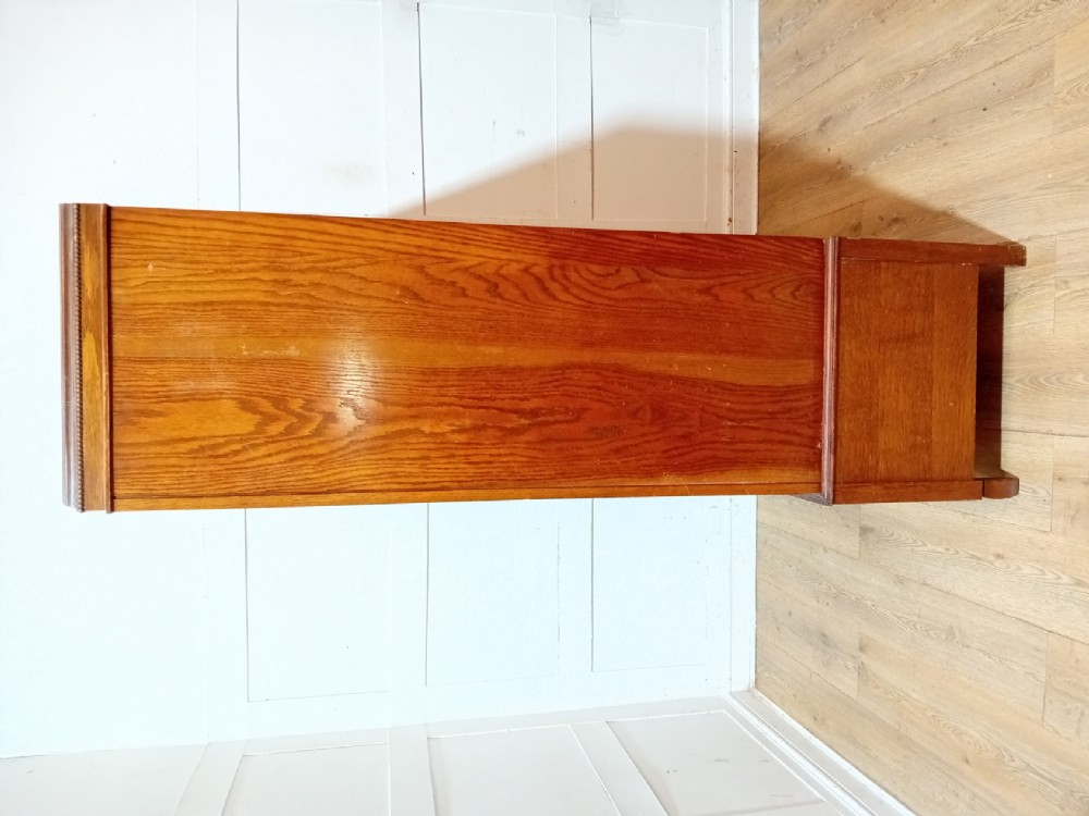 An Edwardian oak compactum wardrobe featuring two panelled doors with chevron oak veneers above a wide single drawer with brass drop handles. View VII