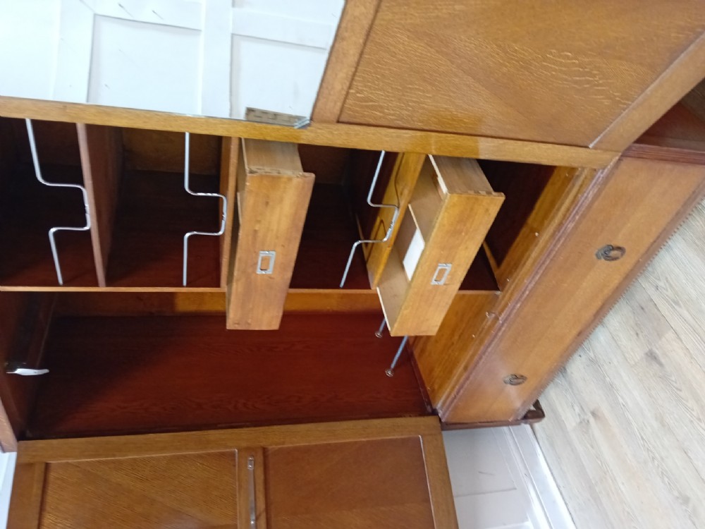 An Edwardian oak compactum wardrobe featuring two panelled doors with chevron oak veneers above a wide single drawer with brass drop handles. View XII