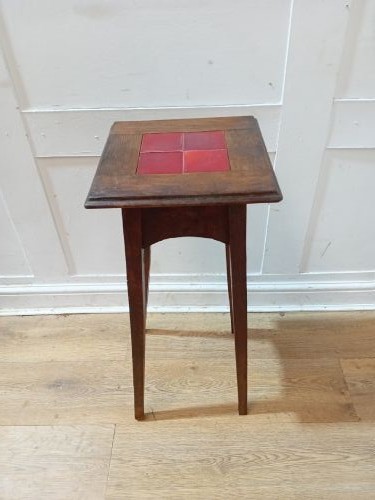 A tall Arts and Crafts dark oak jardiniere stand featuring four red ceramic tiles inset on the top surface and slim tapered legs. View II