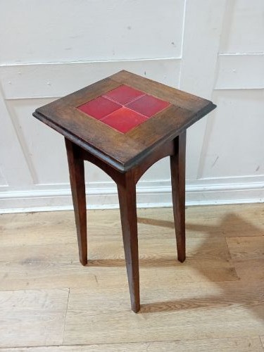 A tall Arts and Crafts dark oak jardiniere stand featuring four red ceramic tiles inset on the top surface and slim tapered legs. View VI