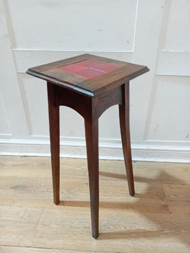 A tall Arts and Crafts dark oak jardiniere stand featuring four red ceramic tiles inset on the top surface and slim tapered legs. View IX