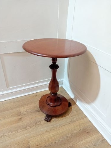 A late Victorian circular mahogany side table featuring a smooth turned pedestal column and a shaped base. View II