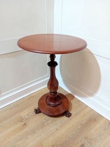 A late Victorian circular mahogany side table featuring a smooth turned pedestal column and a shaped base. View VI