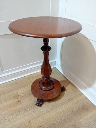 A late Victorian circular mahogany side table featuring a smooth turned pedestal column and a shaped base. View VIII