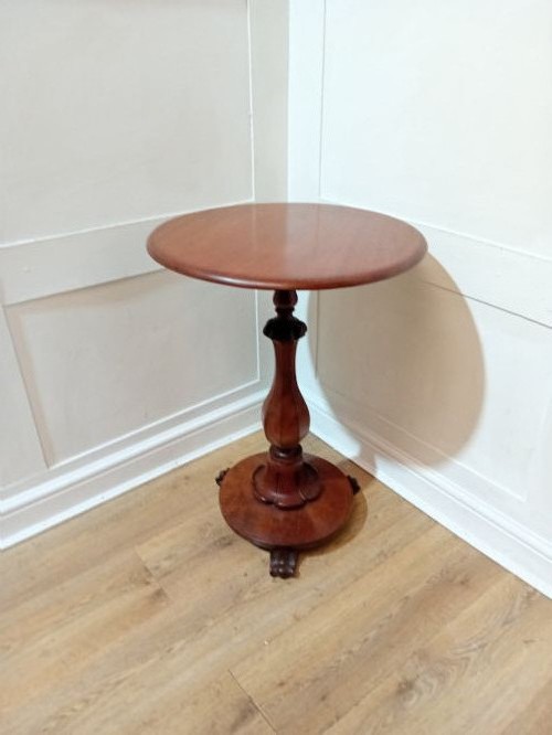 A late Victorian circular mahogany side table featuring a smooth turned pedestal column and a shaped base. View V
