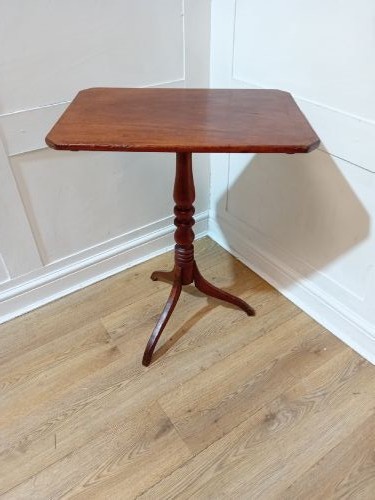 A Georgian oak wine table featuring a rectangular top with canted corners supported by a turned central pedestal and tripod base.