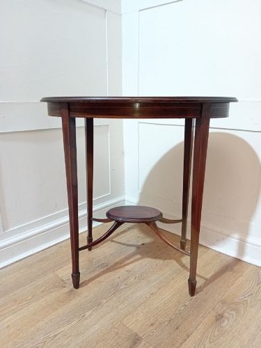 An antique oval dark mahogany occasional table featuring slender tapered legs connected by curved stretchers with a small central circular shelf. View II
