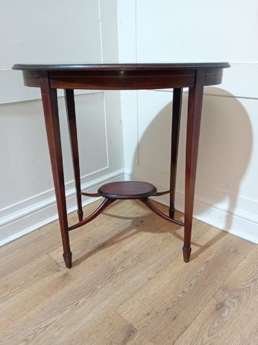 An antique oval dark mahogany occasional table featuring slender tapered legs connected by curved stretchers with a small central circular shelf. View IV