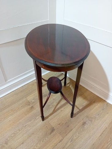 An antique oval dark mahogany occasional table featuring slender tapered legs connected by curved stretchers with a small central circular shelf. View VII