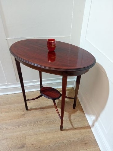 An antique oval dark mahogany occasional table featuring slender tapered legs connected by curved stretchers with a small central circular shelf. View VIII