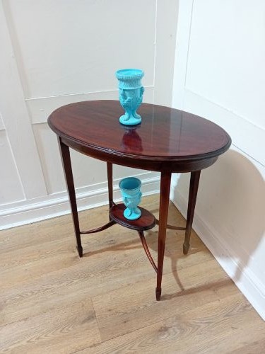 An antique oval dark mahogany occasional table featuring slender tapered legs connected by curved stretchers with a small central circular shelf. View IX