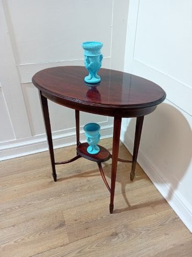 An antique oval dark mahogany occasional table featuring slender tapered legs connected by curved stretchers with a small central circular shelf. View X