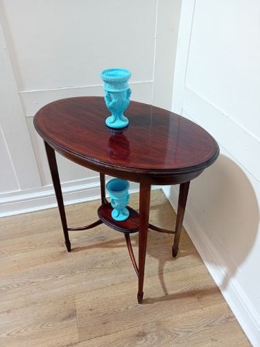An antique oval dark mahogany occasional table featuring slender tapered legs connected by curved stretchers with a small central circular shelf. View XI
