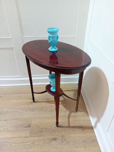 An antique oval dark mahogany occasional table featuring slender tapered legs connected by curved stretchers with a small central circular shelf. View XII