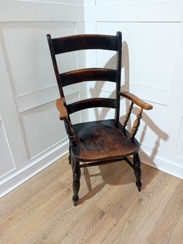 A Victorian Thames Valley Oxford wooden armchair featuring a three-slat ladder back, shaped wooden armrests, a contoured wooden seat, and turned legs with a dark patinated finish. View X