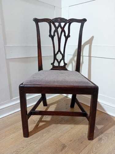 An 18th-century George III mahogany side chair featuring a carved pierced splat back, upholstered drop-in seat, and straight square legs with H-stretcher support. View V