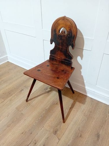 An antique Bavarian folk art wooden side chair featuring a carved cartouche backrest with a central cutout, a slab seat with visible joinery, and splayed legs. View II