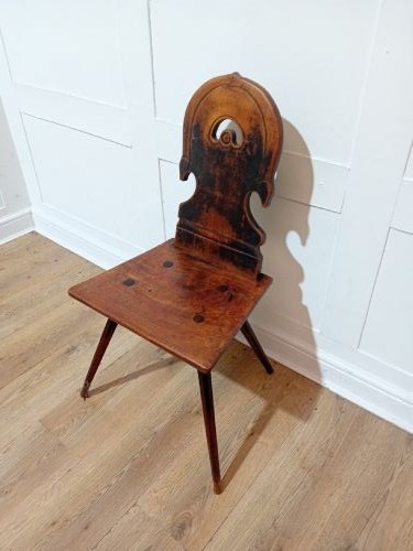 An antique Bavarian folk art wooden side chair featuring a carved cartouche backrest with a central cutout, a slab seat with visible joinery, and splayed legs. View IV