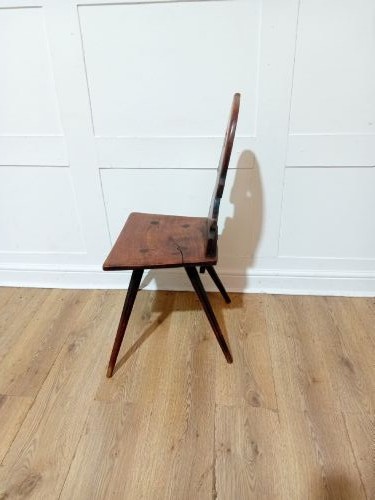 An antique Bavarian folk art wooden side chair featuring a carved cartouche backrest with a central cutout, a slab seat with visible joinery, and splayed legs. View VI