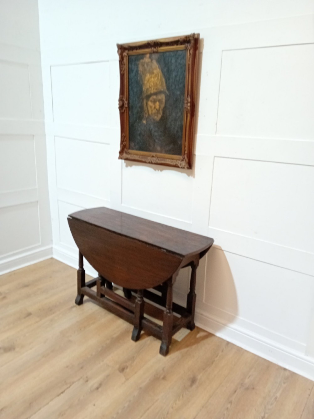 A seventeenth-century dark oak gateleg table with folded leaves, turned legs, and a stretcher base. View II