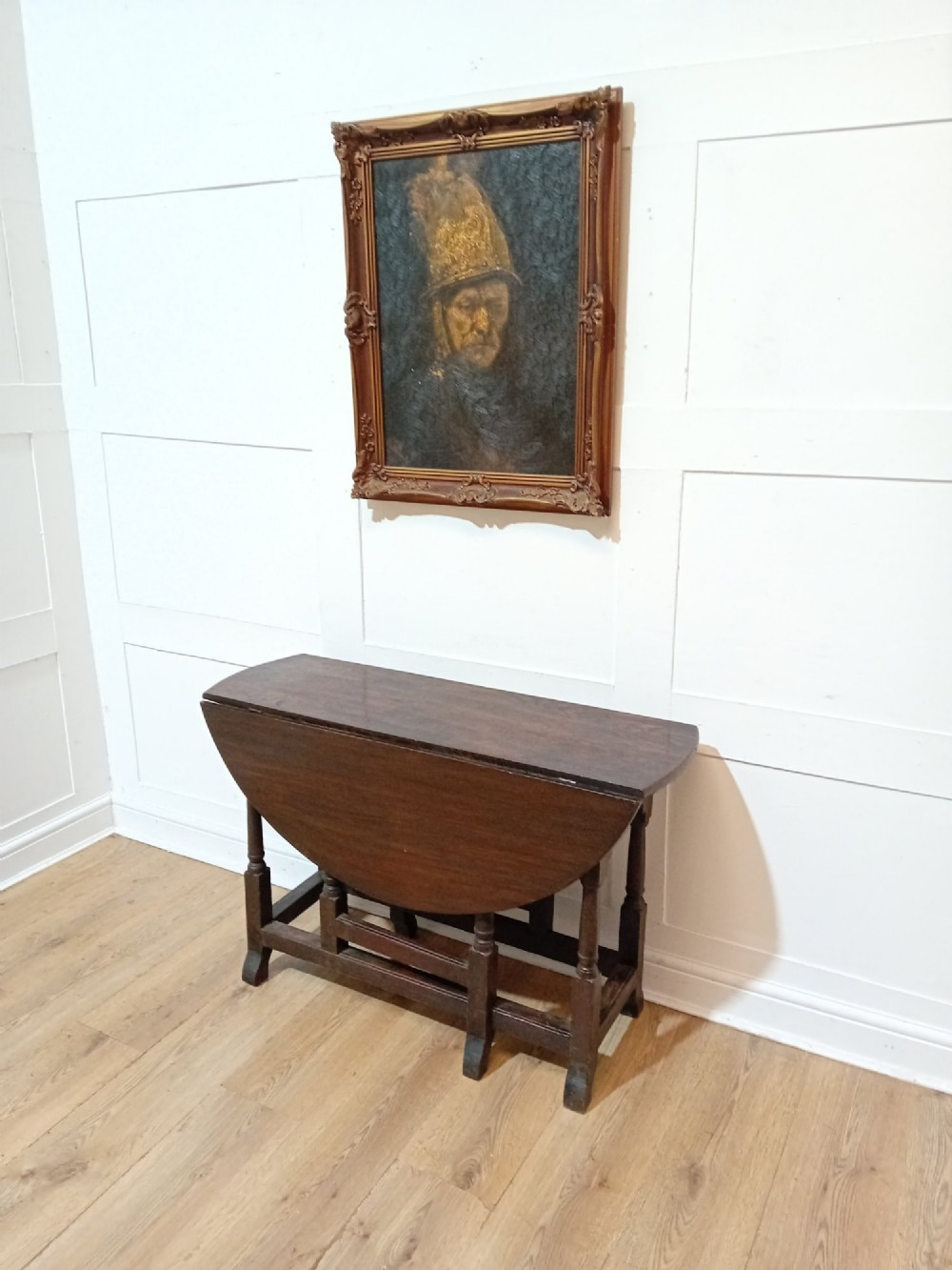 A seventeenth-century dark oak gateleg table with folded leaves, turned legs, and a stretcher base. View III