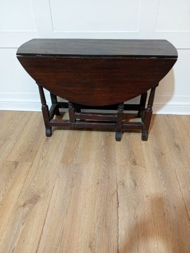 A seventeenth-century dark oak gateleg table with folded leaves, turned legs, and a stretcher base. View V