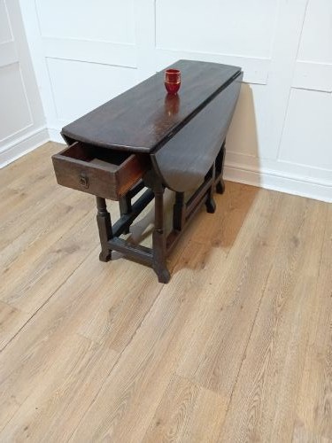 A seventeenth-century dark oak gateleg table with folded leaves, turned legs, and a stretcher base. View VIII