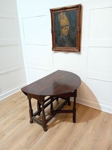 A seventeenth-century dark oak gateleg table with folded leaves, turned legs, and a stretcher base. View IX